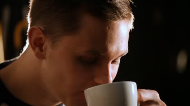 Jeune homme boit du thé dans une tasse blanche — Video