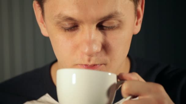 Junger Mann trinkt Tee aus einer weißen Tasse — Stockvideo