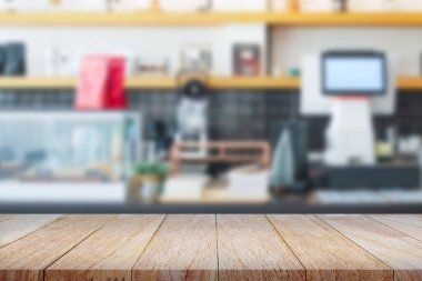 Bulanık kahve dükkanı geçmişi olan boş ahşap bir masa. Ürün gösterimi, montaj veya yiyecek sunumu için mükemmel.