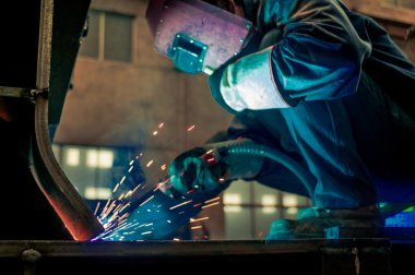 Fabrika kaynakçılar göz kamaştıran bir ışık çalışırken