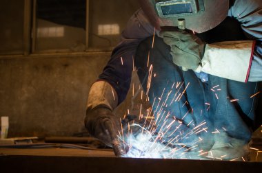 Fabrika kaynakçılar göz kamaştıran bir ışık çalışırken