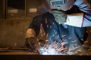 Fabrika kaynakçılar göz kamaştıran bir ışık çalışırken