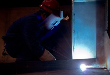 Fabrika kaynakçılar göz kamaştıran bir ışık çalışırken