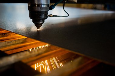 Endüstriyel lazer, düz metal levha ve kıvılcımlar üreten üretim teknolojisini kesiyor.