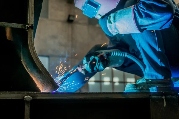 Fabrika kaynakçılar göz kamaştıran bir ışık çalışırken