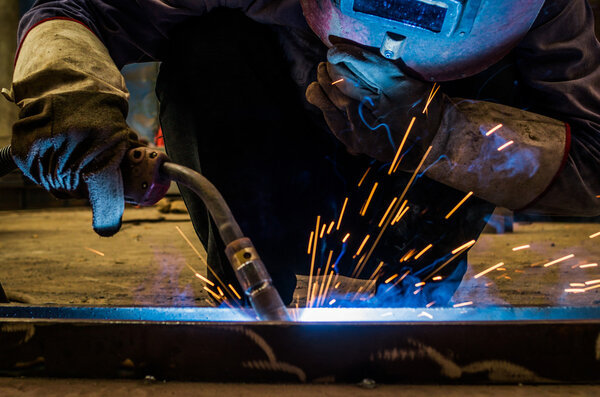Когда фабричные сварщики работают ослепительный свет
