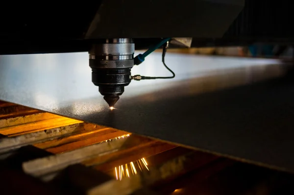 Endüstriyel lazer, düz metal levha ve kıvılcımlar üreten üretim teknolojisini kesiyor.