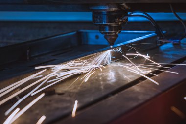 Endüstriyel lazer, düz metal levha ve kıvılcımlar üreten üretim teknolojisini kesiyor.