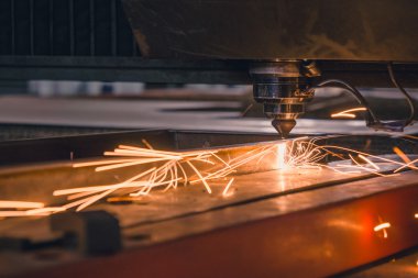 Endüstriyel lazer, düz metal levha ve kıvılcımlar üreten üretim teknolojisini kesiyor.