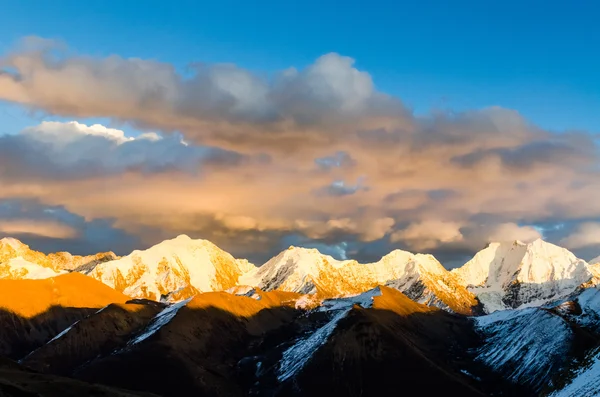 Vue de St. Moritz en Suisse : haute chaîne de montagnes montagneuses couvertes de neige et de glace avec des sommets éclairés rouges au coucher du soleil et la lune dehors — Photo