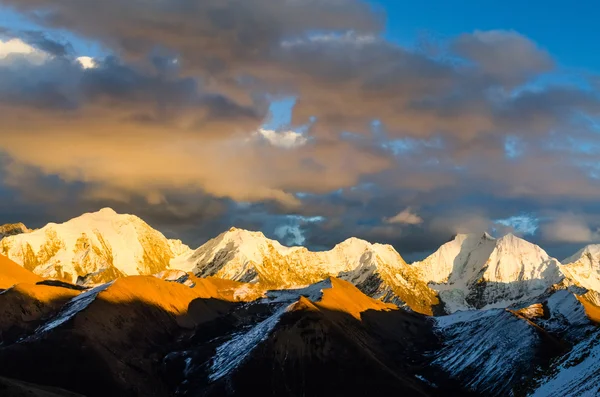 Vista desde St. Moritz en Suiza: alta nieve y cordillera alpina cubierta de hielo con picos iluminados rojos al atardecer y la luna hacia fuera — Foto de Stock