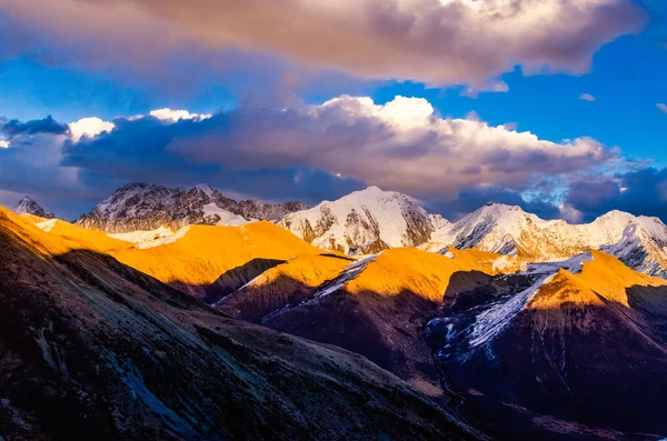 Vista desde St. Moritz en Suiza: alta nieve y cordillera alpina cubierta de hielo con picos iluminados rojos al atardecer y la luna hacia fuera — Foto de Stock