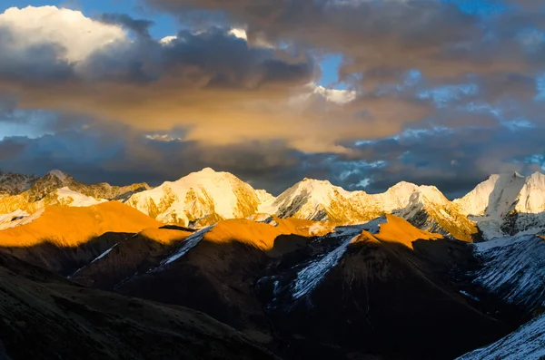 Blick von St. Moritz in der Schweiz: hohe schnee- und eisbedeckte Bergkette mit rot beleuchteten Gipfeln bei Sonnenuntergang und Monduntergang — Stockfoto