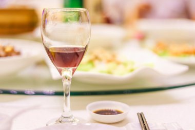 bardak kırmızı şarap ve yemek masada