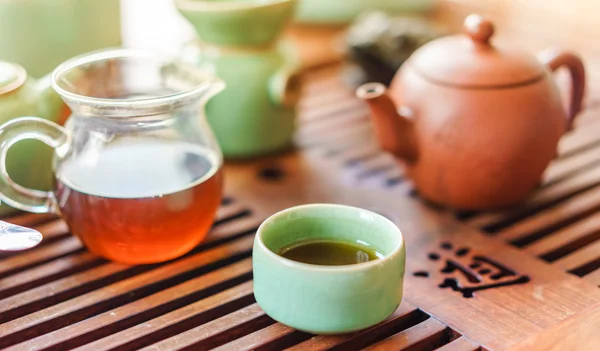 Tetera verde y taza de té con bolsa de té en una foto de textura blanca. Colores naturales —  Fotos de Stock