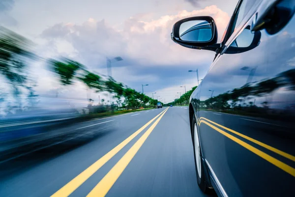 Zijaanzicht van zwarte auto rijden op de landweg. — Stockfoto