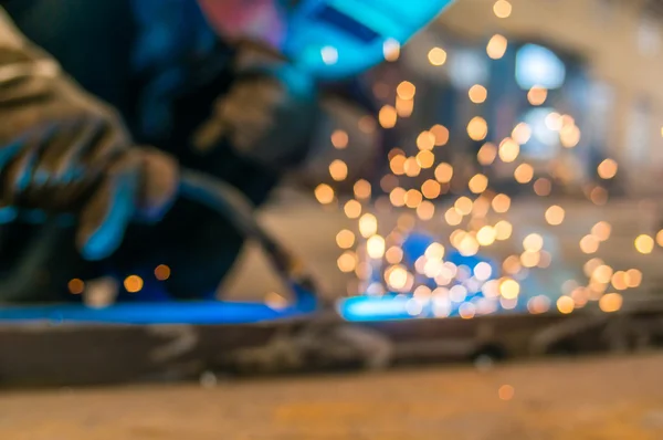 Těžký průmysl svářeč pracovník v ochranné masky ruce drží obloukové svařovací hořák pracuje na kovové konstrukce — Stock fotografie