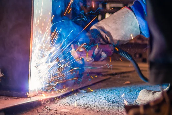 Soldador e faíscas brilhantes. Produção e construção — Fotografia de Stock