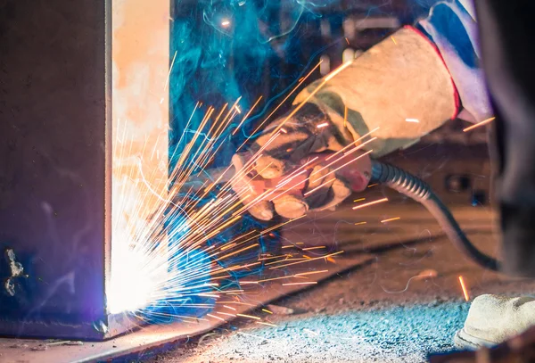 Soldador e faíscas brilhantes. Produção e construção — Fotografia de Stock