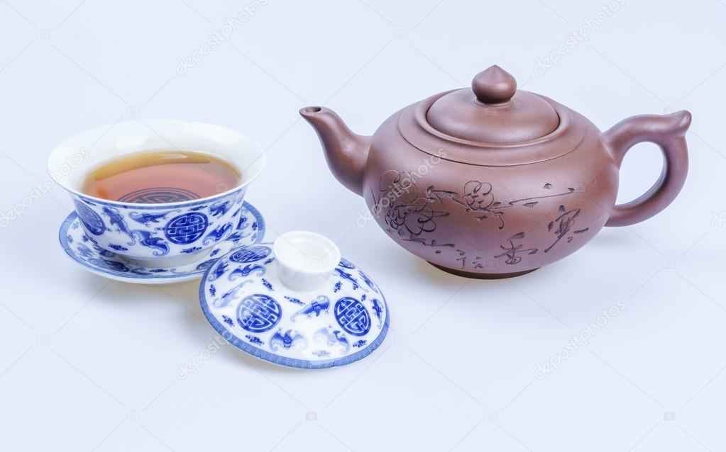 Porcelain teapot and teacup on white background