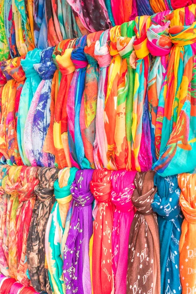 The multi-colored  scarves  hanging  on a wooden  hanger. — Stock Photo, Image