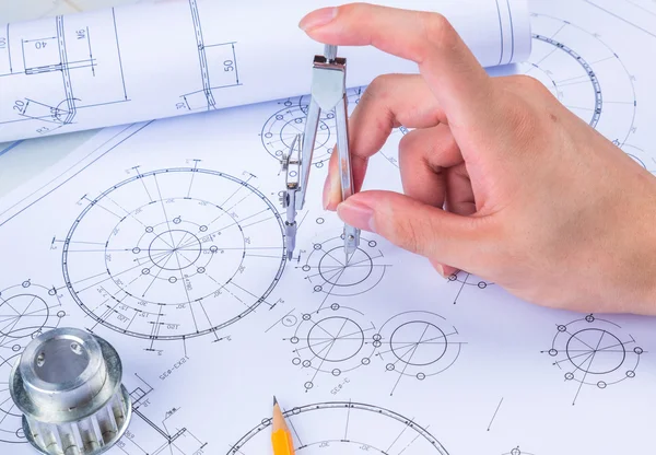 Man's hand with a compass. Mechanical engineer at work. Technical drawings. Pencil, compass, calculator and hand man. Paper with technical drawings and diagrams. — 스톡 사진