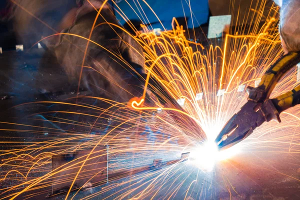 Sparks while welder uses torch to welding — Stock Photo, Image