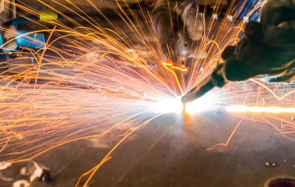 Faíscas enquanto soldador usa tocha para soldagem — Fotografia de Stock