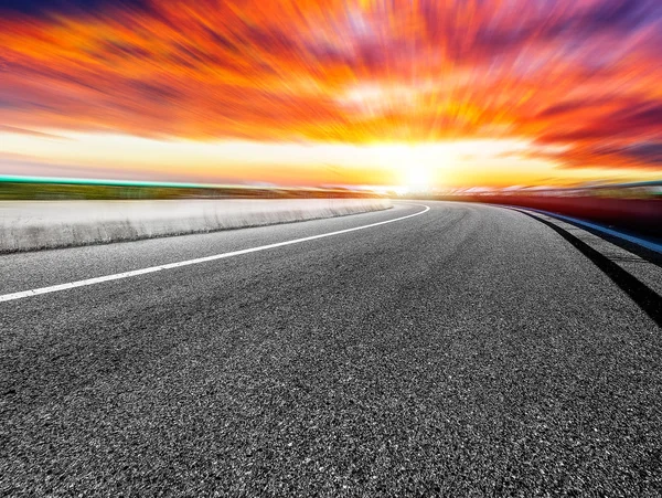 Pôr do sol vermelho sobre a estrada — Fotografia de Stock