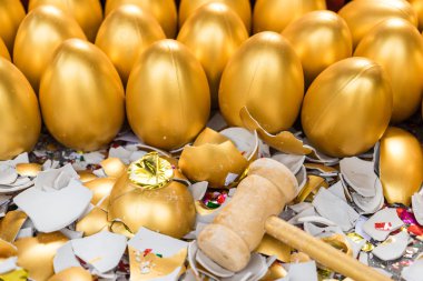 A lucky game, with a wooden hammer smashed the golden egg for the gift inside clipart