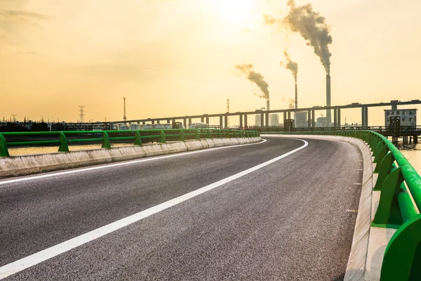 Wide angle landscape photograph of a road leading to a power plant — Stock Photo, Image