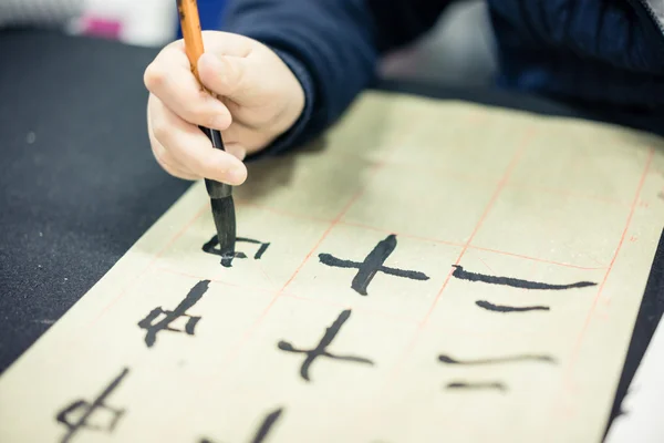 Crianças chinesas aprendem a escrever caracteres chineses, caligrafia é a cultura tradicional da China — Fotografia de Stock