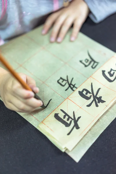 Los niños chinos aprenden a escribir caracteres chinos, la caligrafía es la cultura tradicional de China —  Fotos de Stock