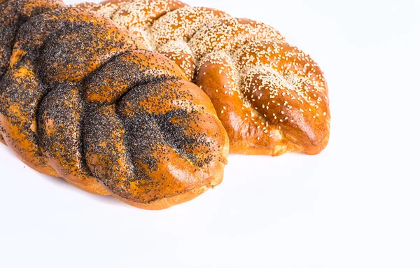 Zwei ganze frische Challah-Brote mit Mohn und Sesam auf einem Tisch — Stockfoto