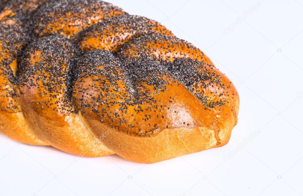 Two whole fresh challah bread with poppy and sesame seeds on a w
