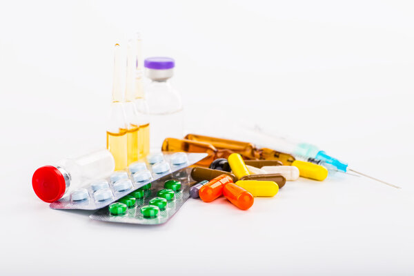 Various cold prescription bottles and a syringe isolated on a wh