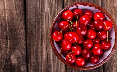 Taze Olgun Kiraz ahşap bir masa üzerinde reçelli.