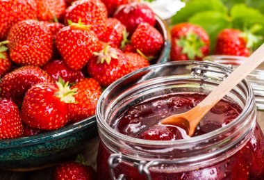 Çilek ahşap arka plan üzerinde. Çilek yeşil yaprakları ile.