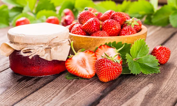 Erdbeere auf Holz Hintergrund. Erdbeere mit grünen Blättern. — Stockfoto