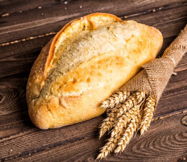 Ahşap masa arkasında pişmiş ekmek çeşitleri