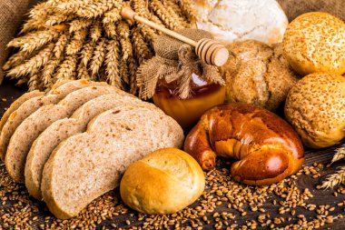 Ahşap masa arkasında pişmiş ekmek çeşitleri