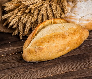 Ahşap masa arkasında pişmiş ekmek çeşitleri