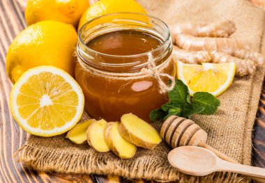 Bal tarak, taze limon ve zencefil ahşap bir masa üzerinde