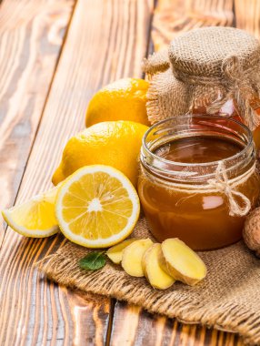 Bal tarak, taze limon ve zencefil ahşap bir masa üzerinde