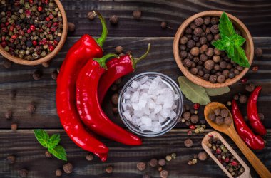 Siyah tahta masa arkaplanındaki kaşıklardaki toz baharatları