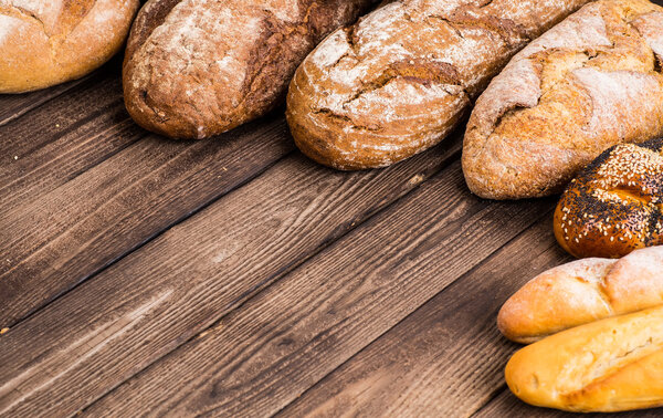 Many mixed breads and rolls shot from above.