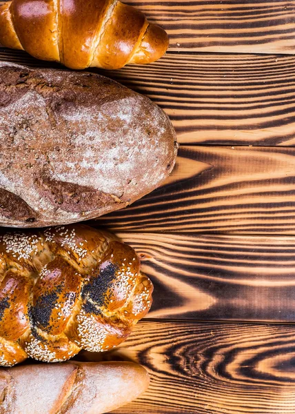 Surtido de pan horneado en mesa de madera —  Fotos de Stock