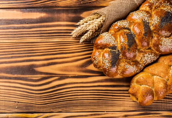 Assortment of baked bread on wooden table background — Stock Photo, Image