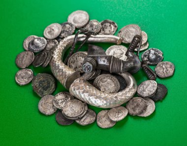 Antique treasure trove of Roman coins and jewelry clipart