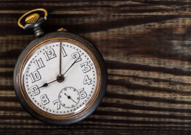 Eski ahşap masa üzerinde eski cep saati.